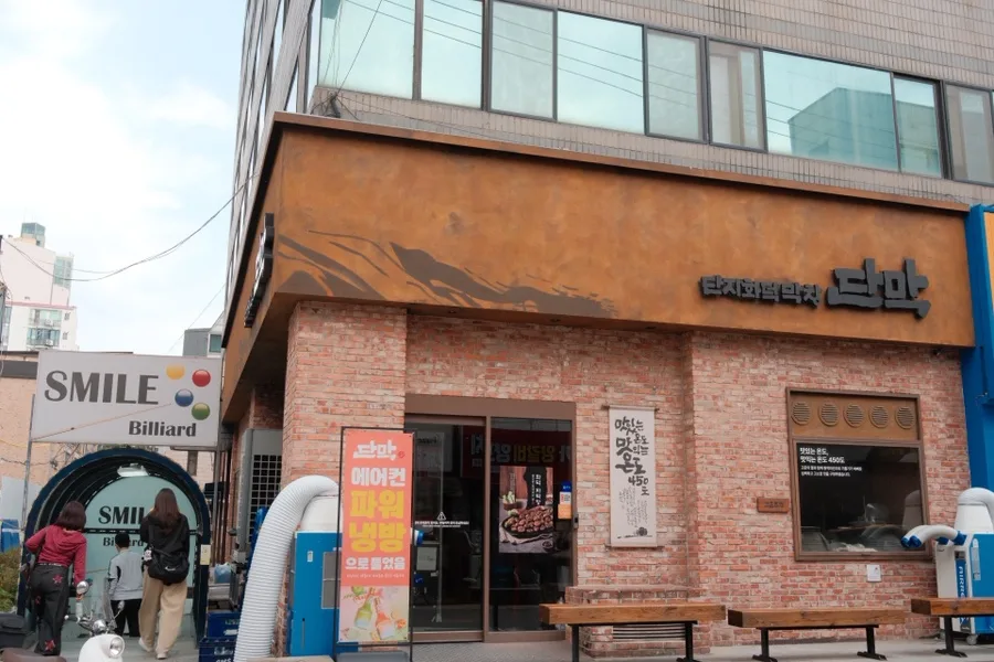 ダンマク 石村湖店 — レンガ壁に店名が掲げられた店先