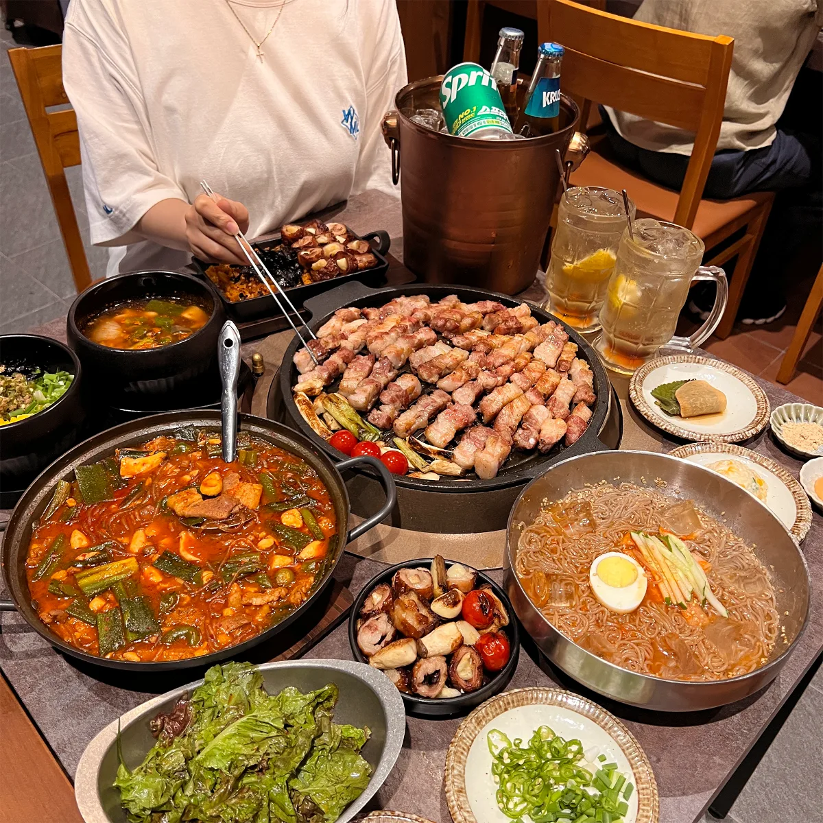 ダンマク 石村湖店 — 焼き肉を囲む料理の並んだ食卓