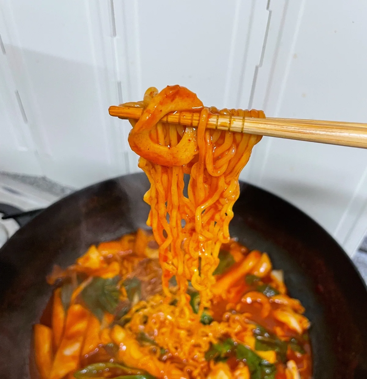 鍋から持ち上げたラーメンとチョルミョン