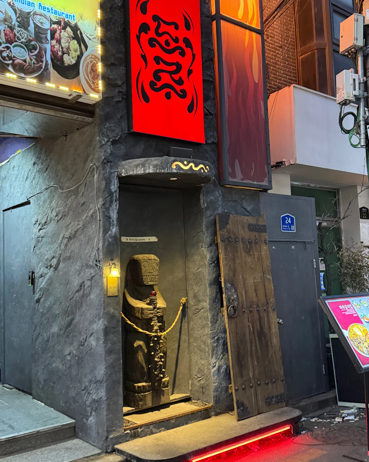 DOJU — 赤い看板と石像のある入口