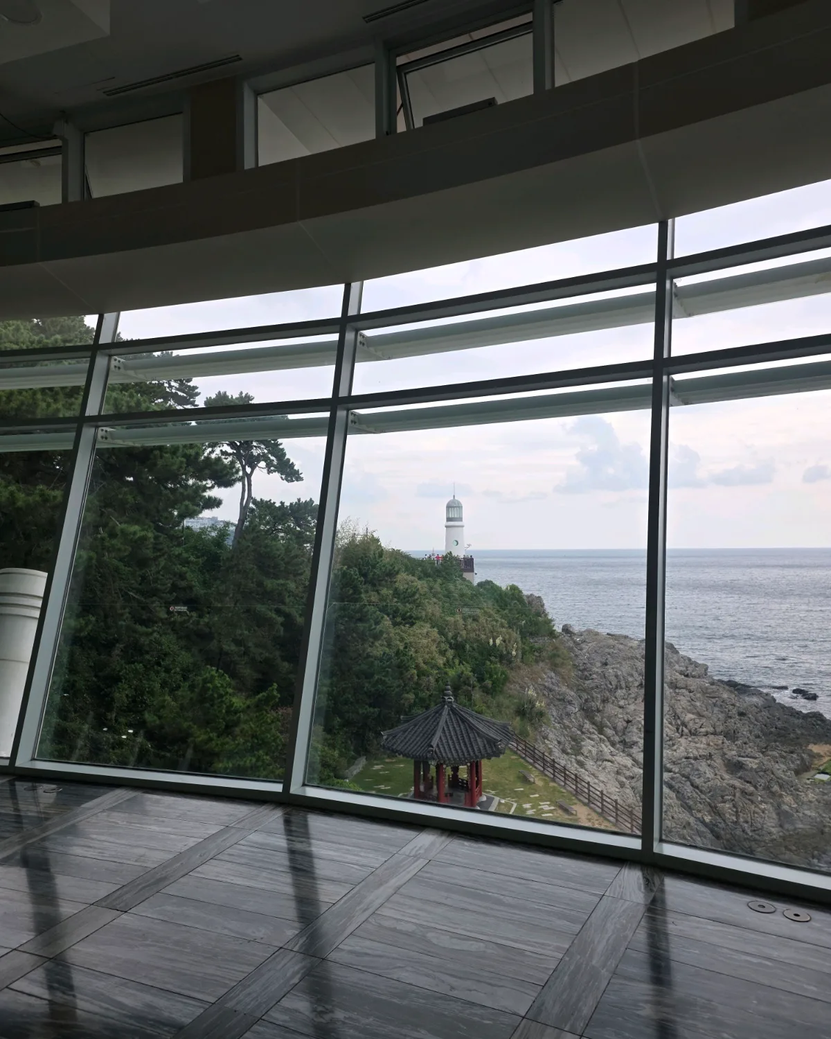 窓越しの灯台と海岸