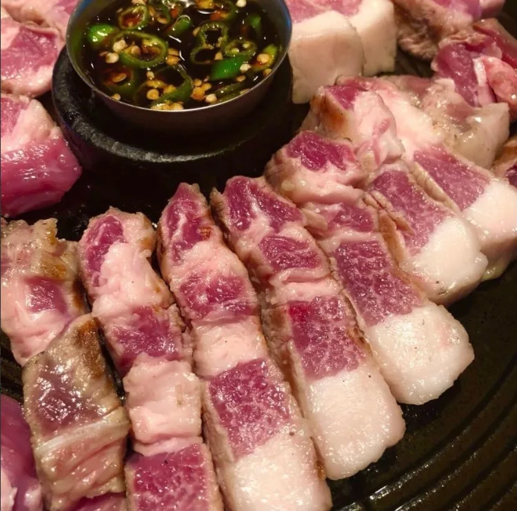 ドンジュヌンナムジャ 本店 — 鉄板に並ぶ厚切り豚肉