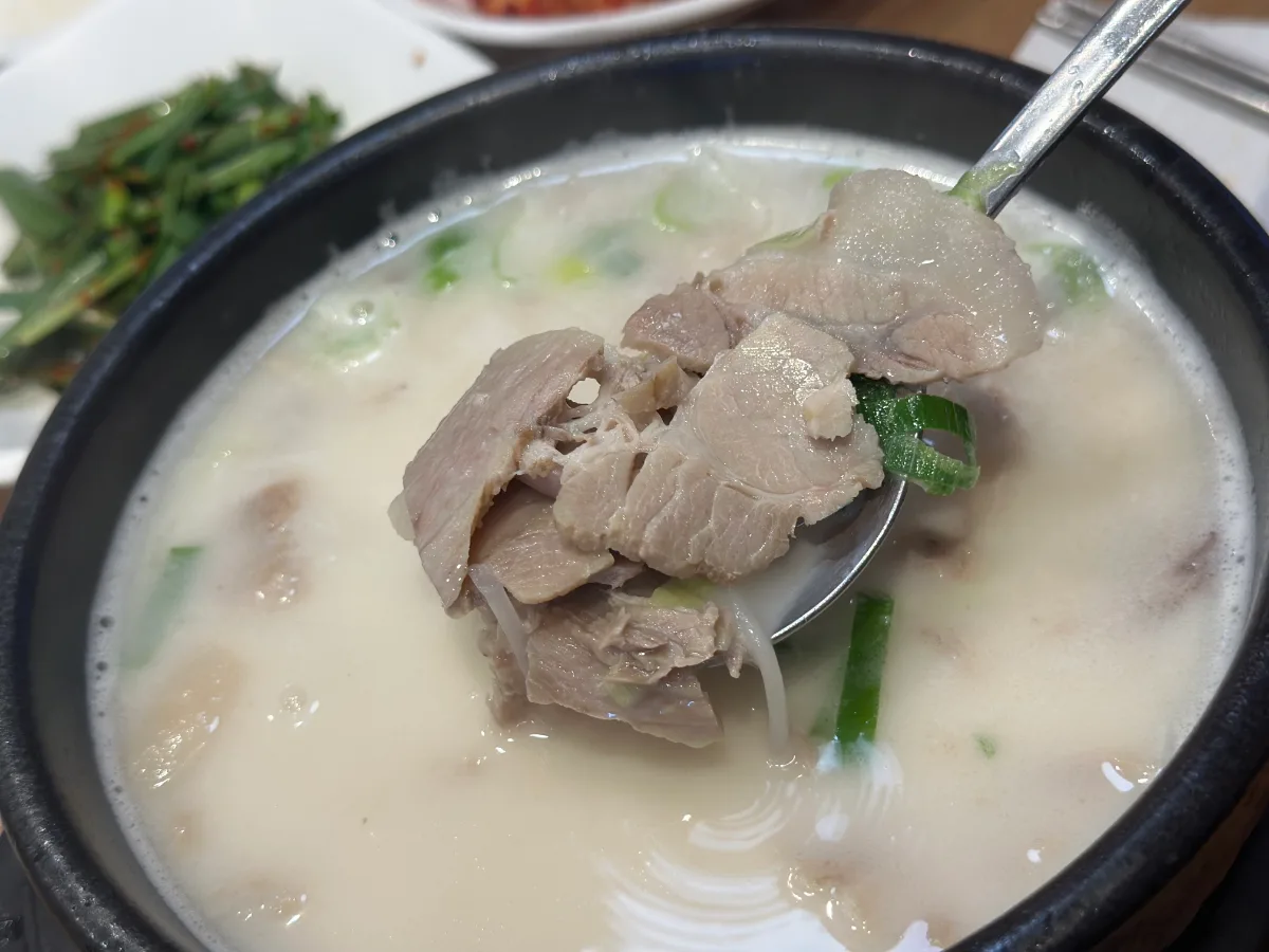 豚寿百 弘大直営店 — 白いスープからすくったゆで豚