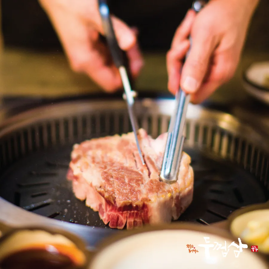 厚切りの豚肉をはさみで切る手元