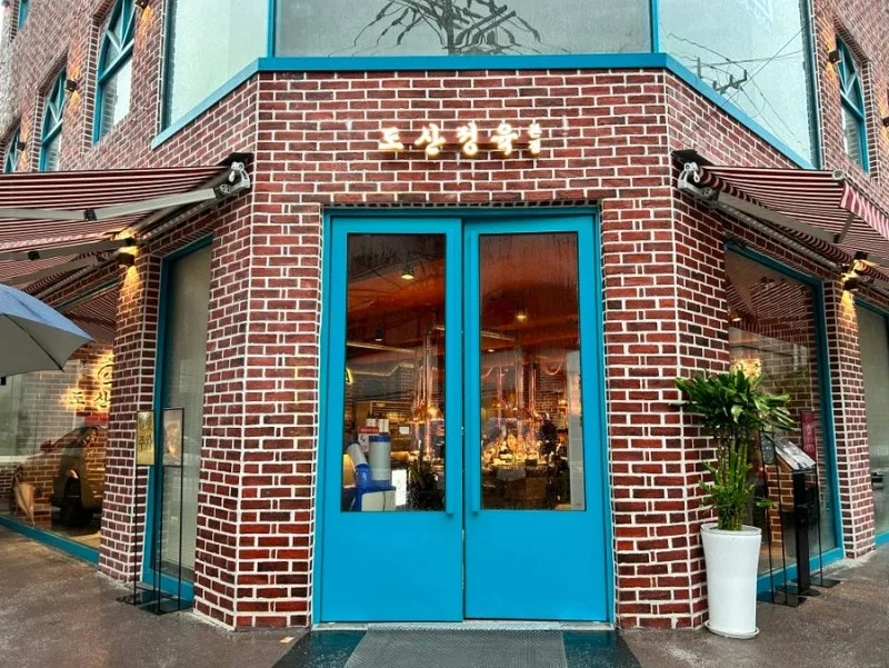 島山精肉 清潭本店 — 青い扉が映える煉瓦の店舗