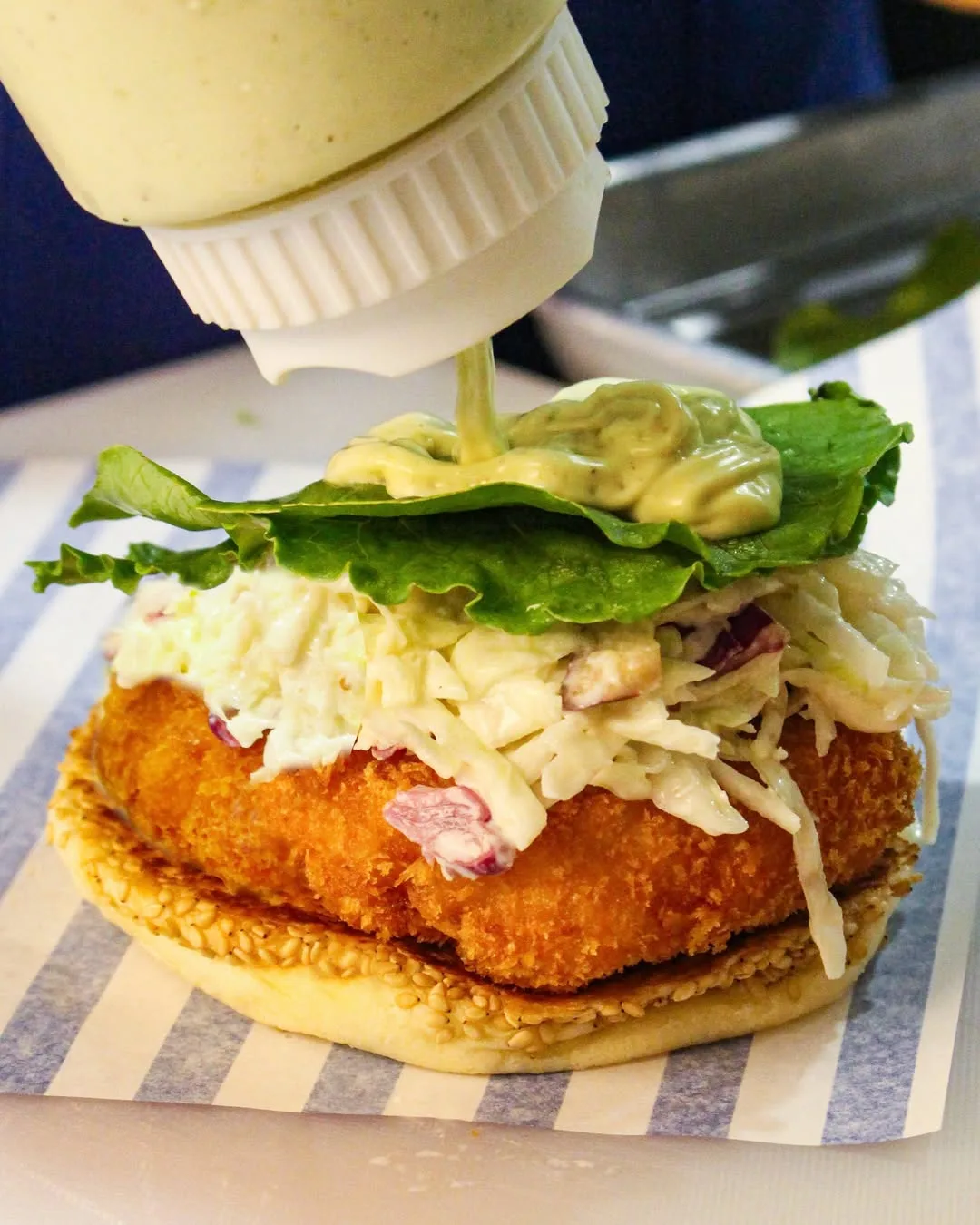 ソースをかける海老バーガー