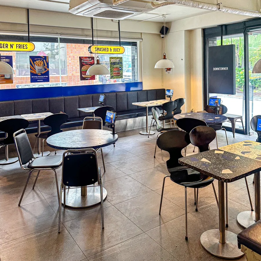 青いベンチと丸卓が並ぶ店内
