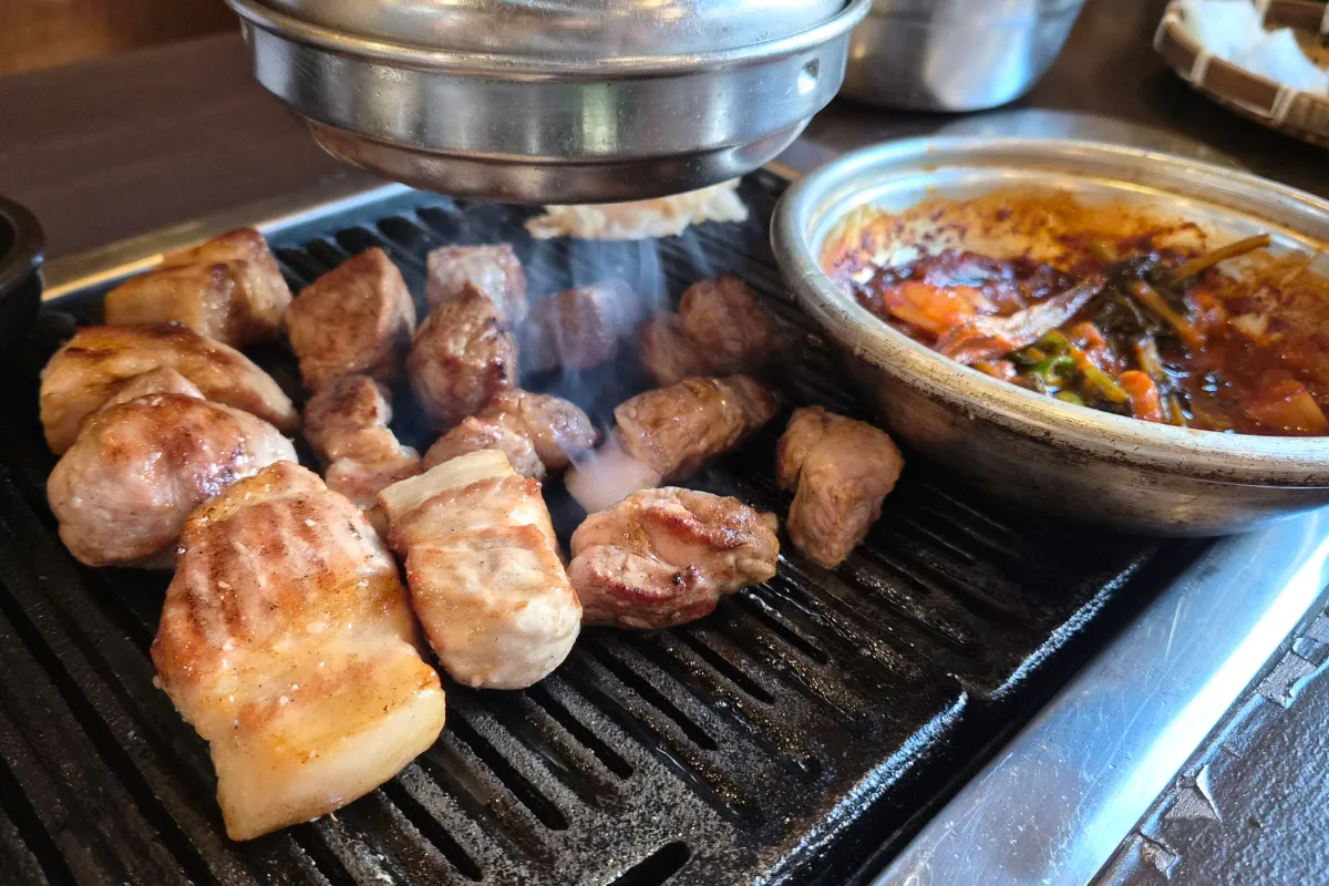 焼き目のついた豚肉と赤い鍋