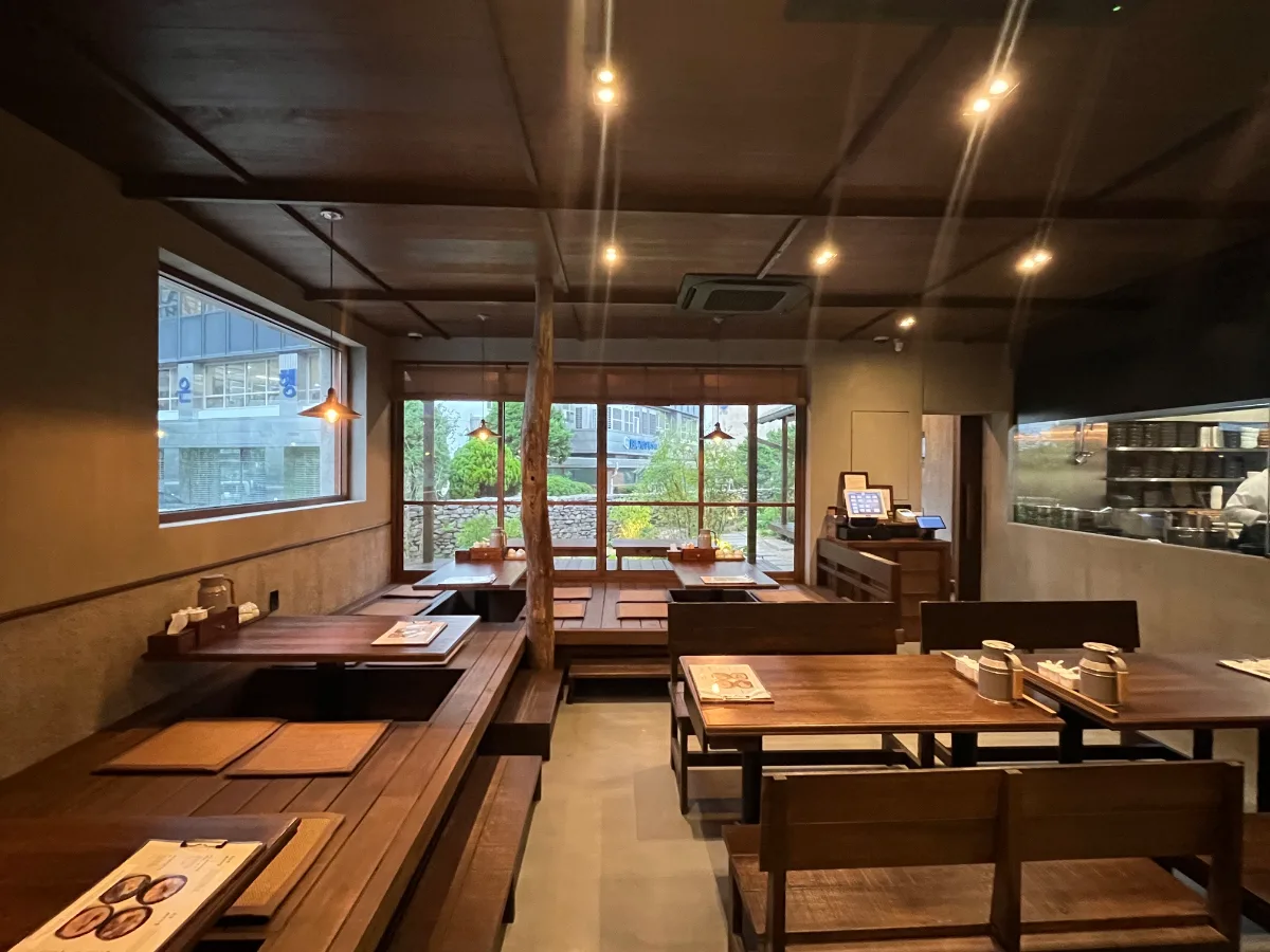 オム・ヨンベク テジクッパ 鐘閣店 — 窓際の座敷席と木のテーブル