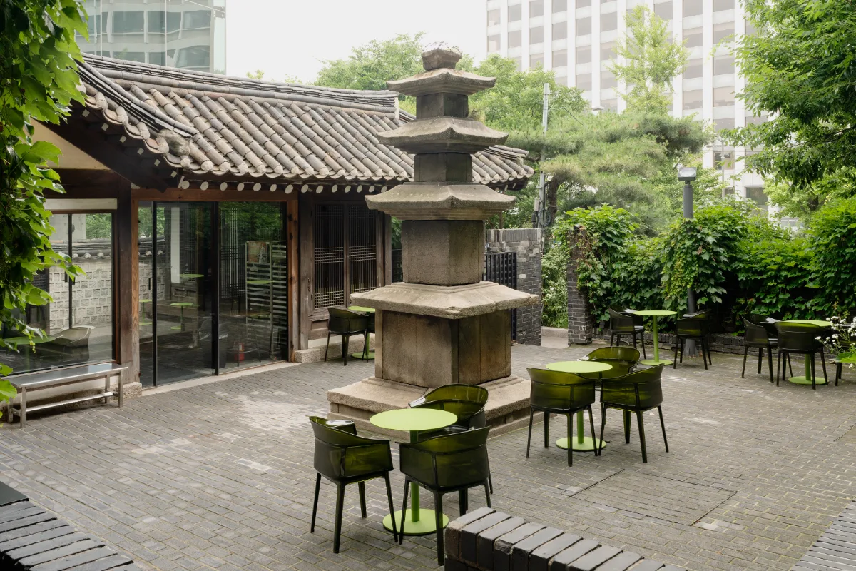 FRITZ 苑西店 — 石塔と緑の丸卓がある中庭