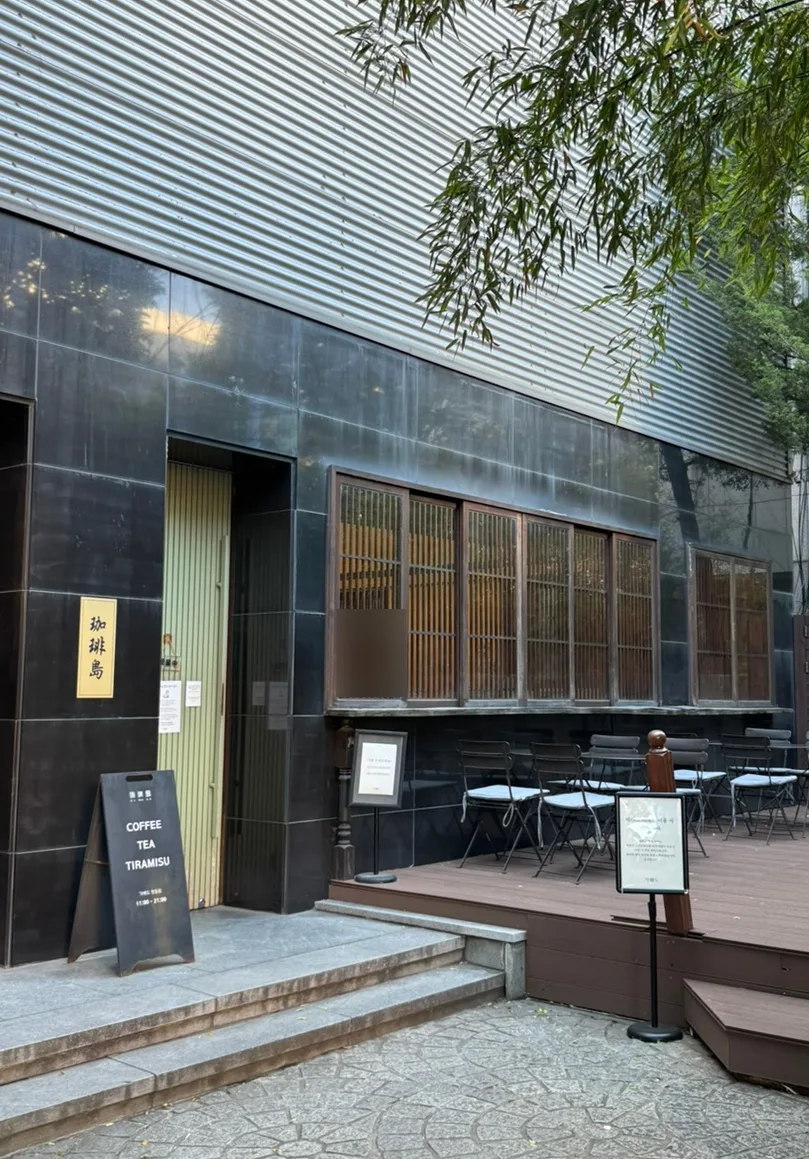 珈琲島 明洞店 — 黒い壁と木窓の店先