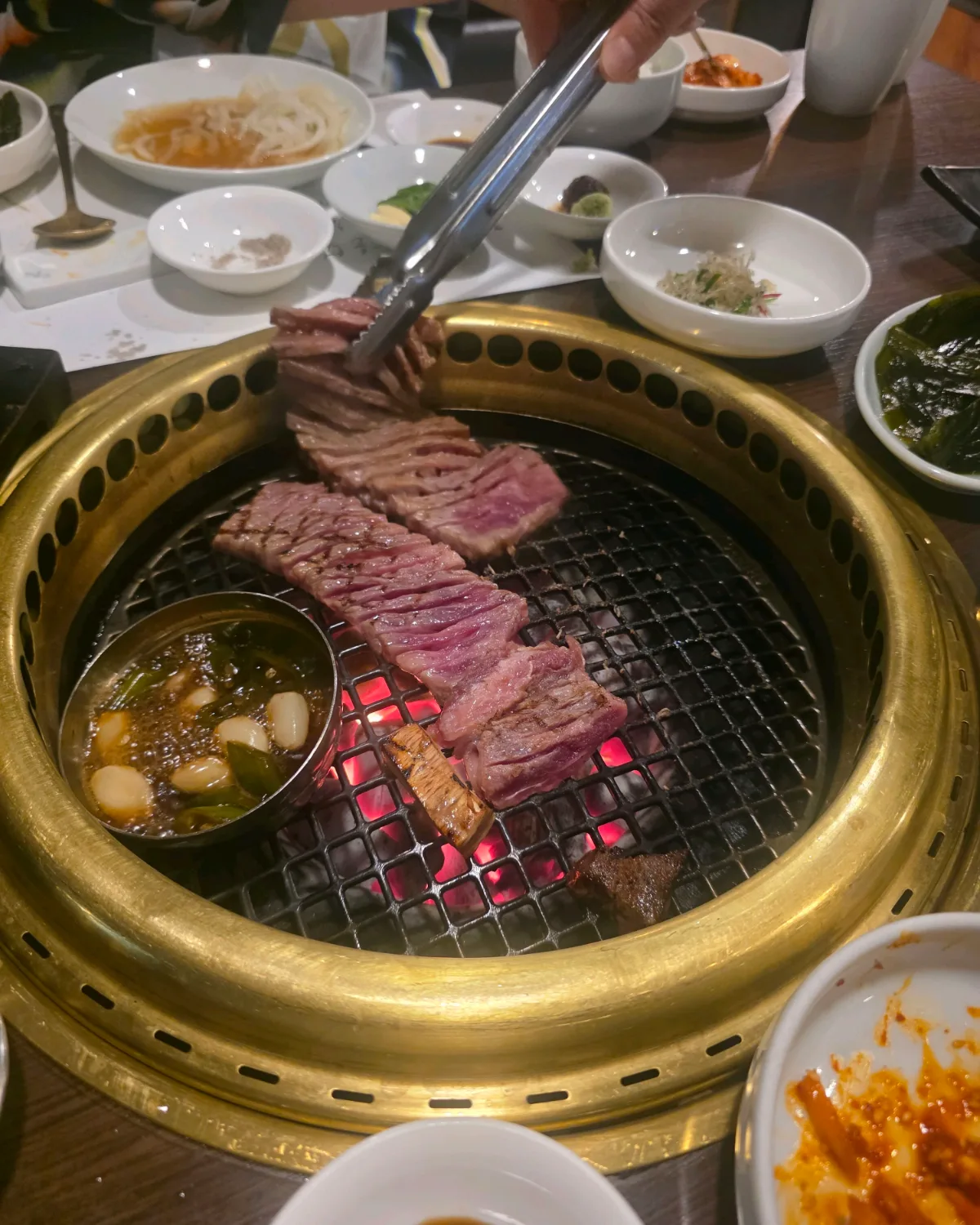 網の上で肉を焼くスタッフの手