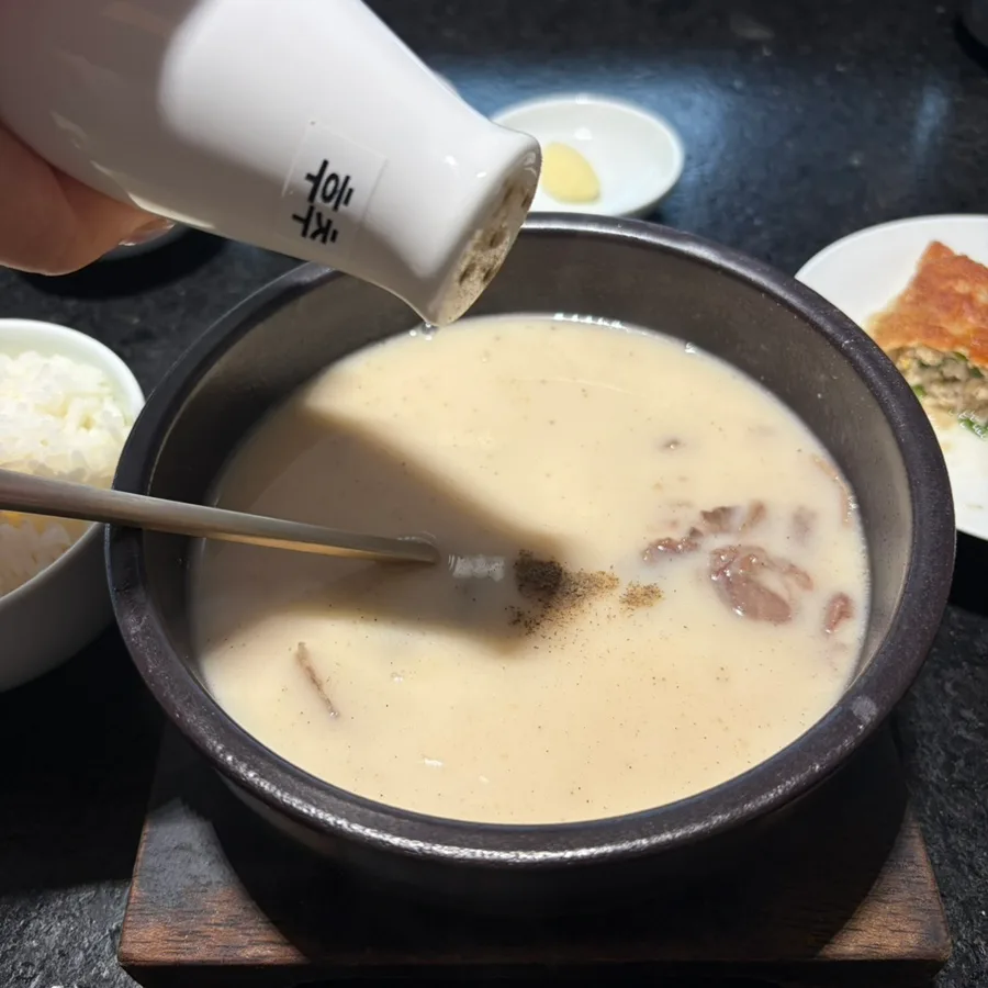 白濁スープに薬味を加える様子