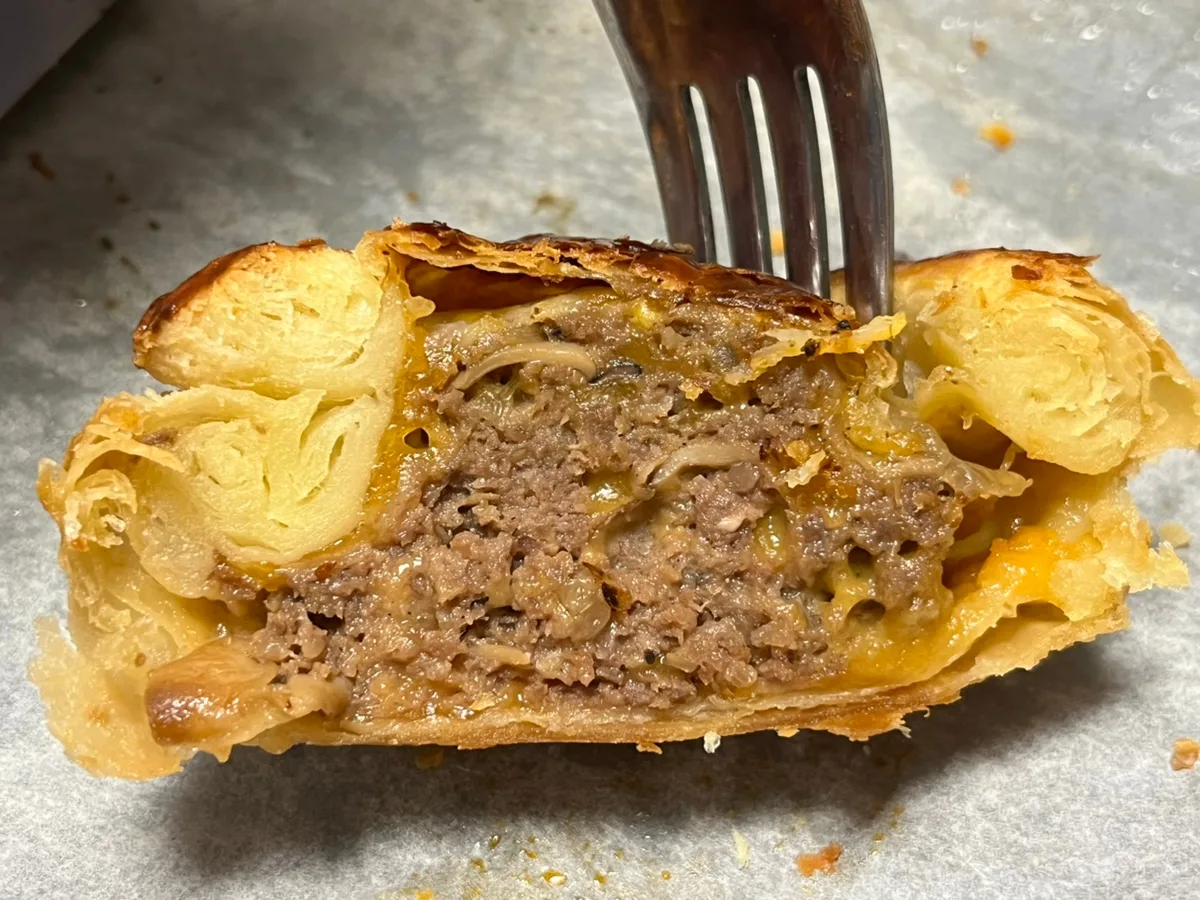 肉ときのこが見えるパイの断面