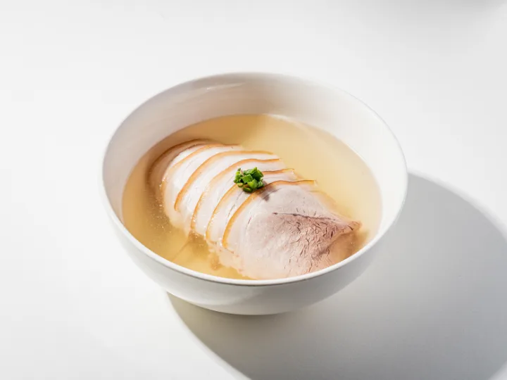 澄んだスープに並ぶ豚肉