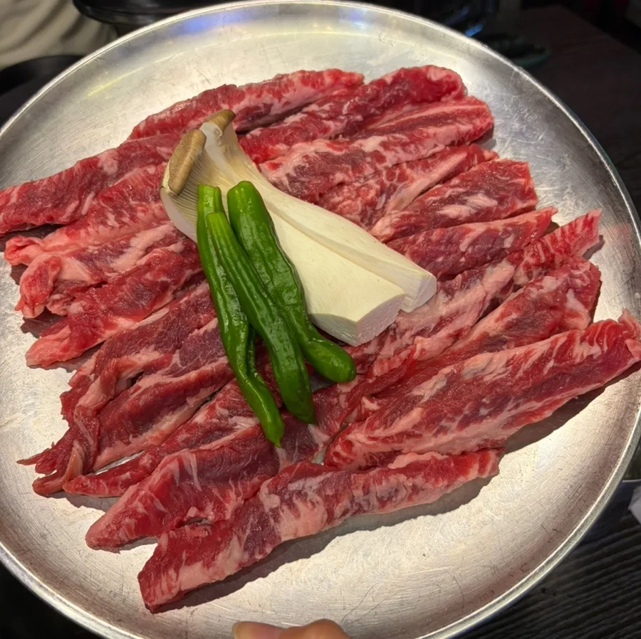 青唐辛子とエリンギを添えた生牛カルビ肉の皿