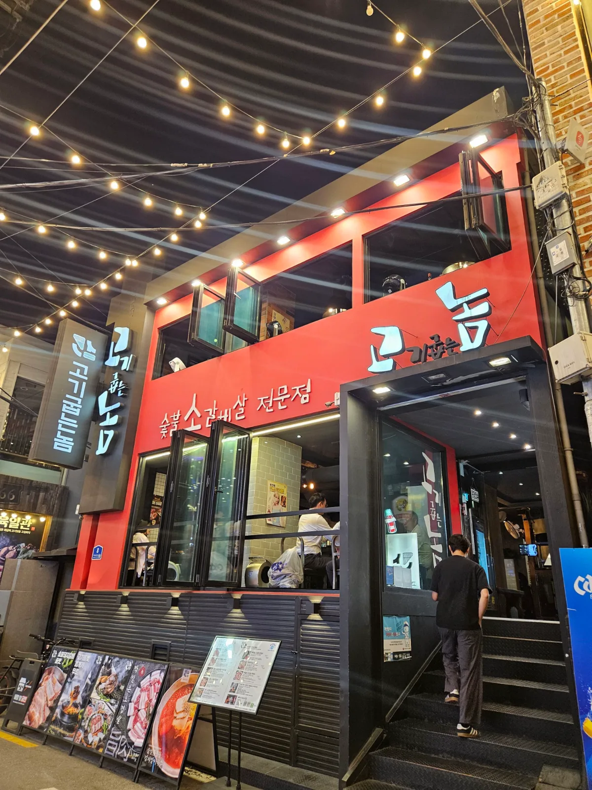 赤い外壁と縦長の看板が目印の店先
