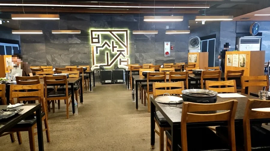 彦陽プルコギ釜山チプ — 焼き網付きの卓が並ぶ店内