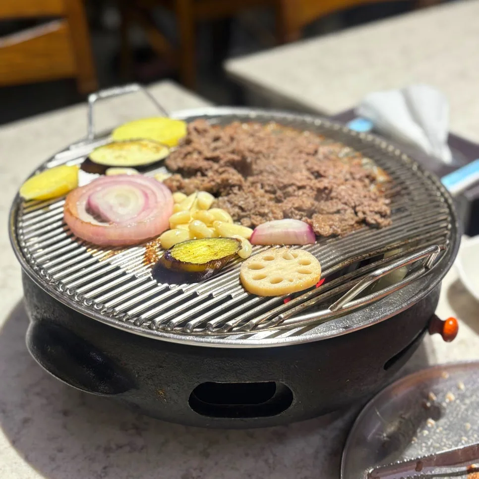 彦陽プルコギ釜山チプ — 炭火の焜炉の網で焼く彦陽プルコギと野菜