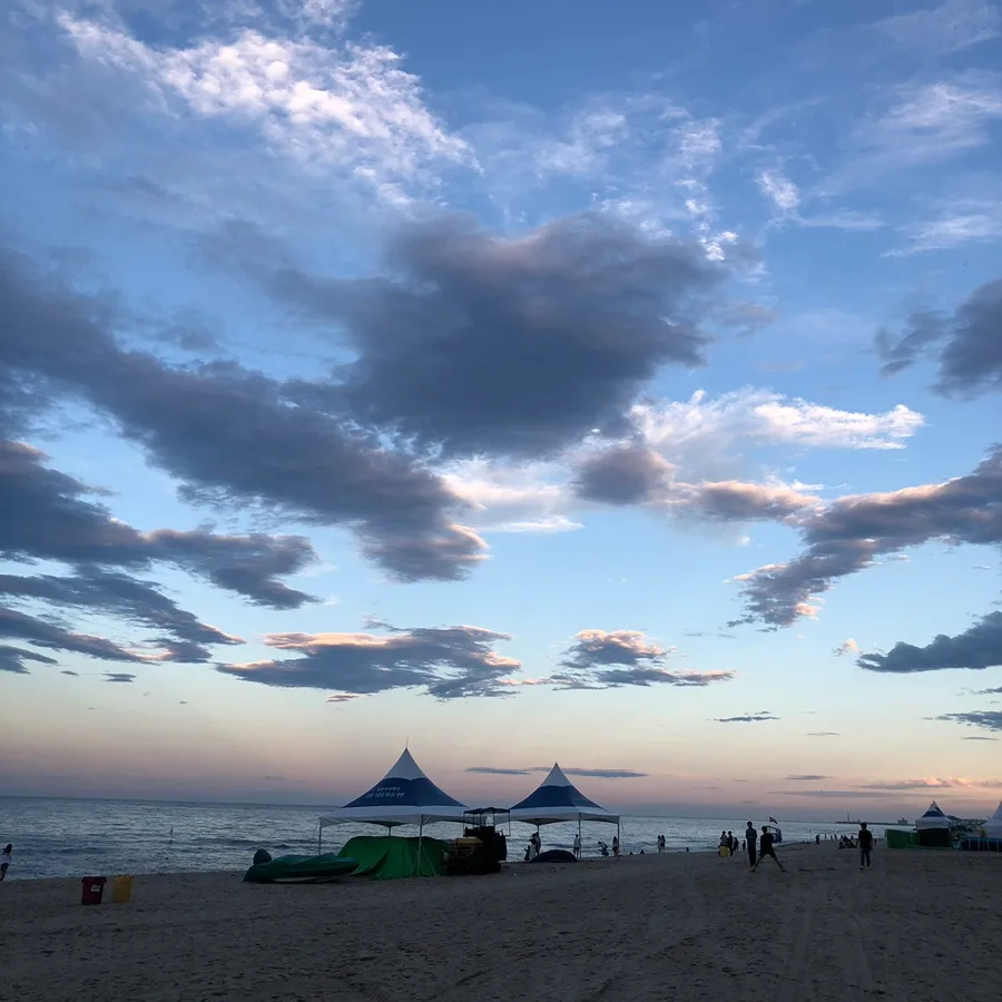夕雲とテントが並ぶ砂浜