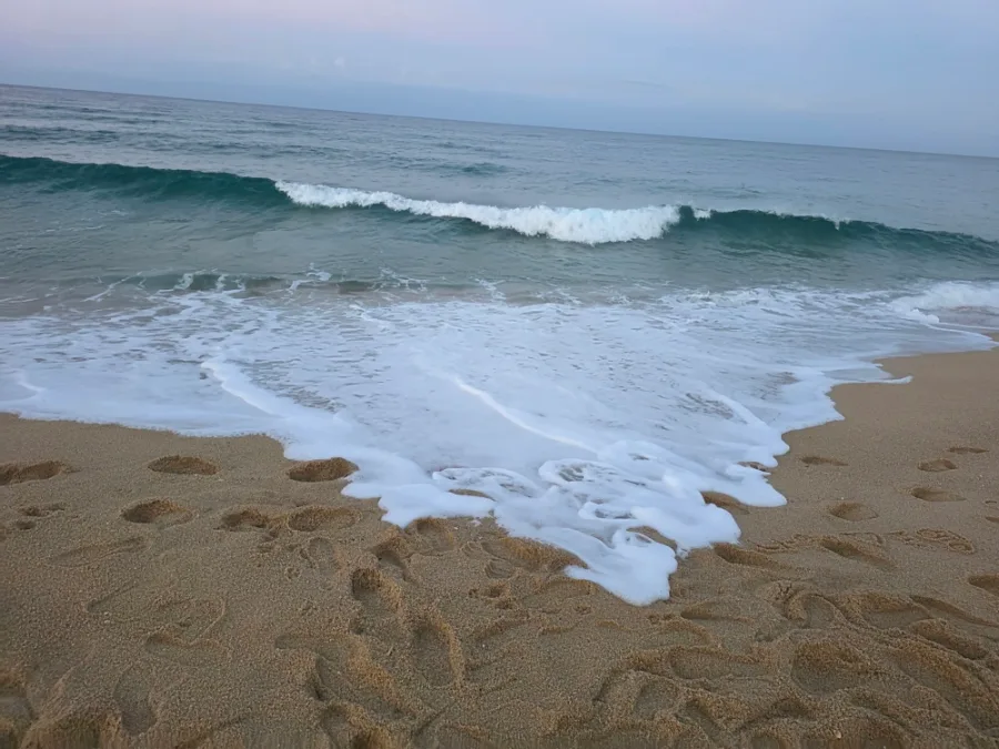 鏡浦海水浴場 — 白波が広がる足跡の砂浜
