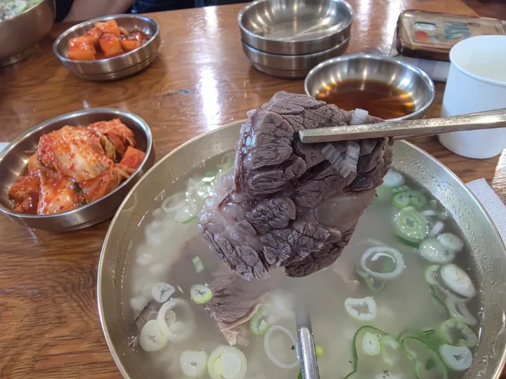 箸で持ち上げた牛肉と澄んだ汁
