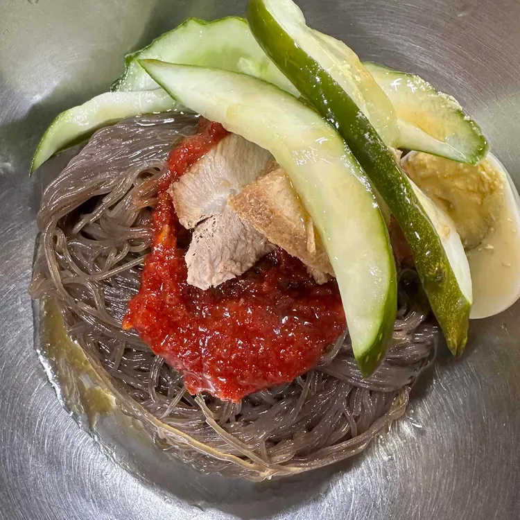 赤いタレとキュウリをのせた冷麺