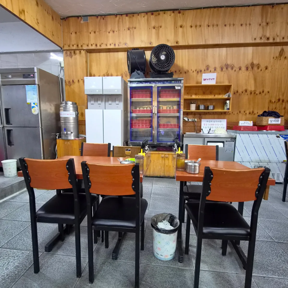 海州冷麺 本店 — 木壁に囲まれた店内のテーブル席