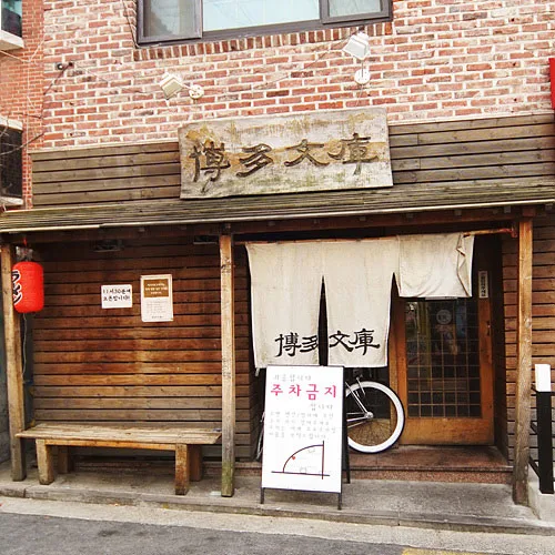 木看板とのれんが掛かる店先
