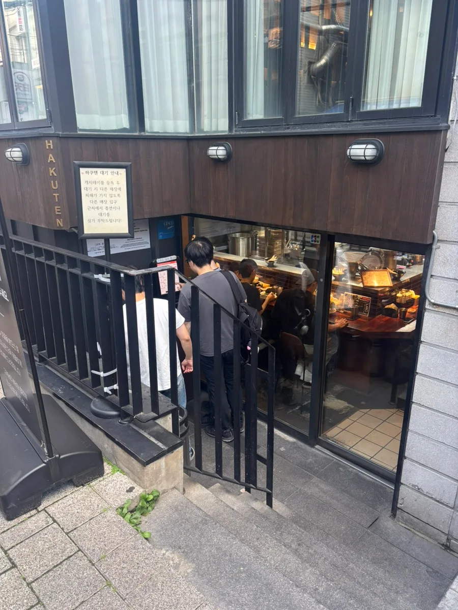 階段に並ぶ客と店の入り口
