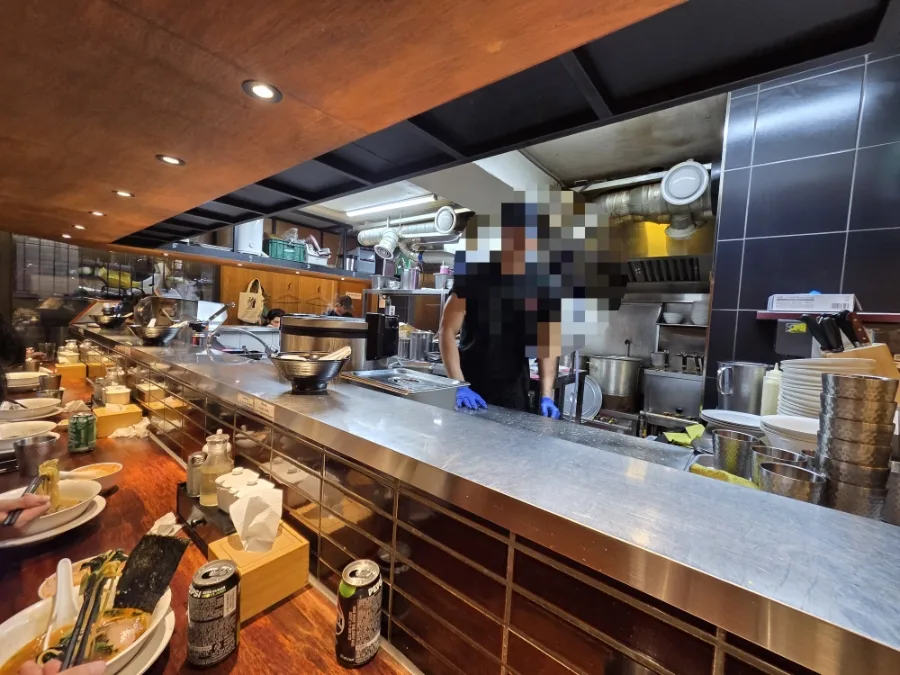 白天 — 厨房カウンターと丼が並ぶ店内