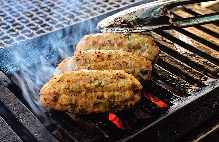 トングで返す炭火焼きのハンバーグ3個