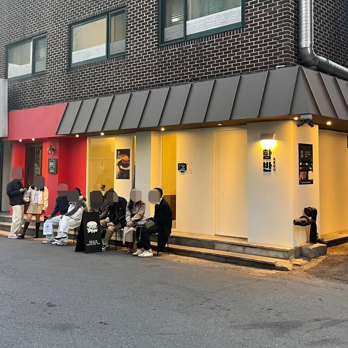ハムバン — 赤い外壁の店先で待つ人々