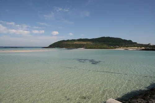澄んだ浅瀬と緑の丘
