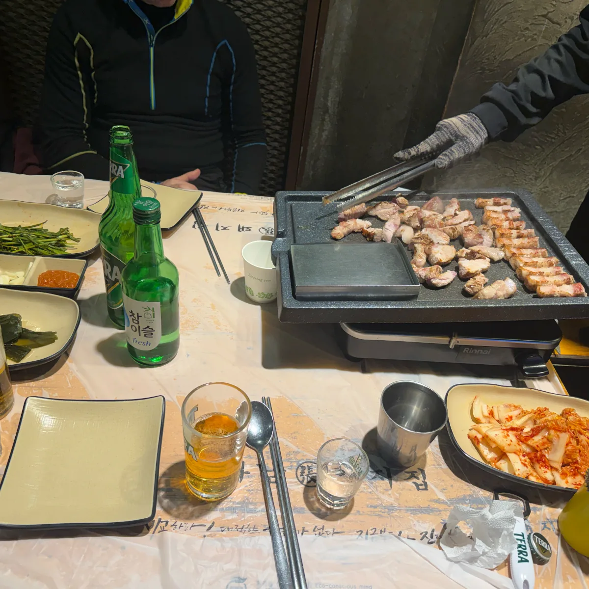 河南テジチッ 明洞1号店 — 鉄板の豚肉と卓上のキムチ