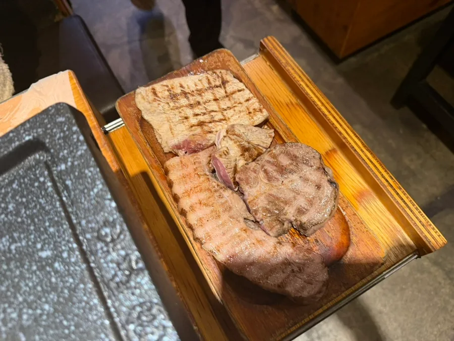 河南テジチッ 明洞1号店 — 木皿に載った数種類の豚肉