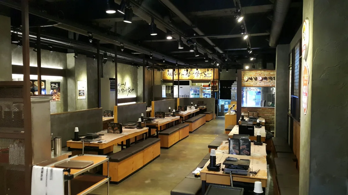 河南テジチッ 明洞1号店 — 鉄板付きのテーブルが並ぶ店内