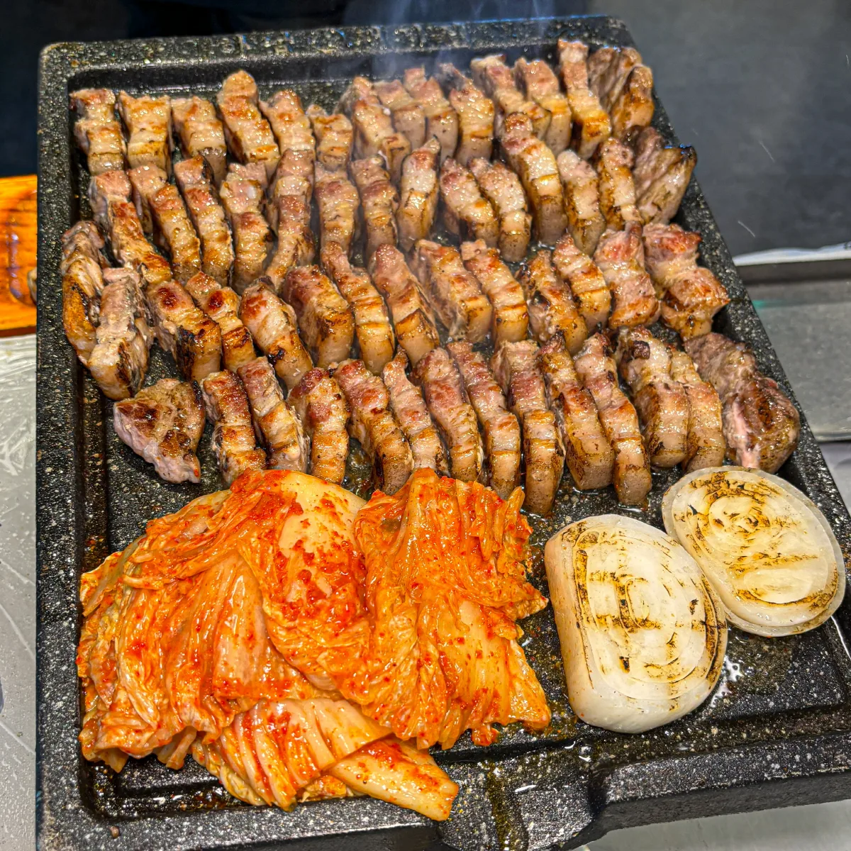 キムチと玉ねぎを添えた焼き豚肉