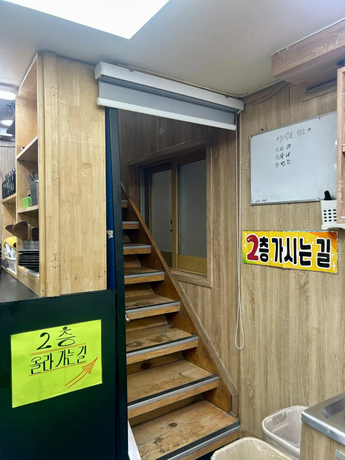 木の階段と2階案内表示