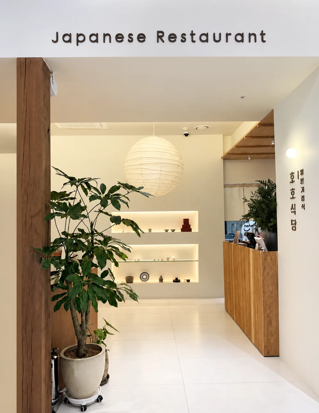 植木と木製カウンターのある入口