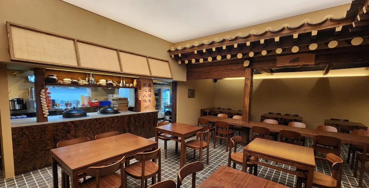 虎彝食 安国店 — 韓屋の梁と木製テーブル席
