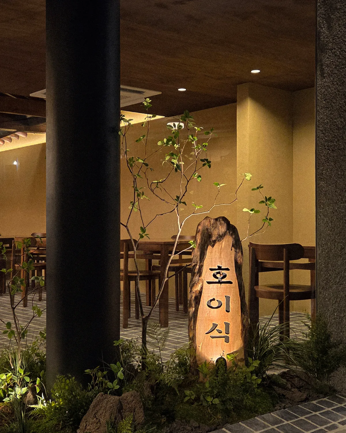 木の店名板と植栽の入口