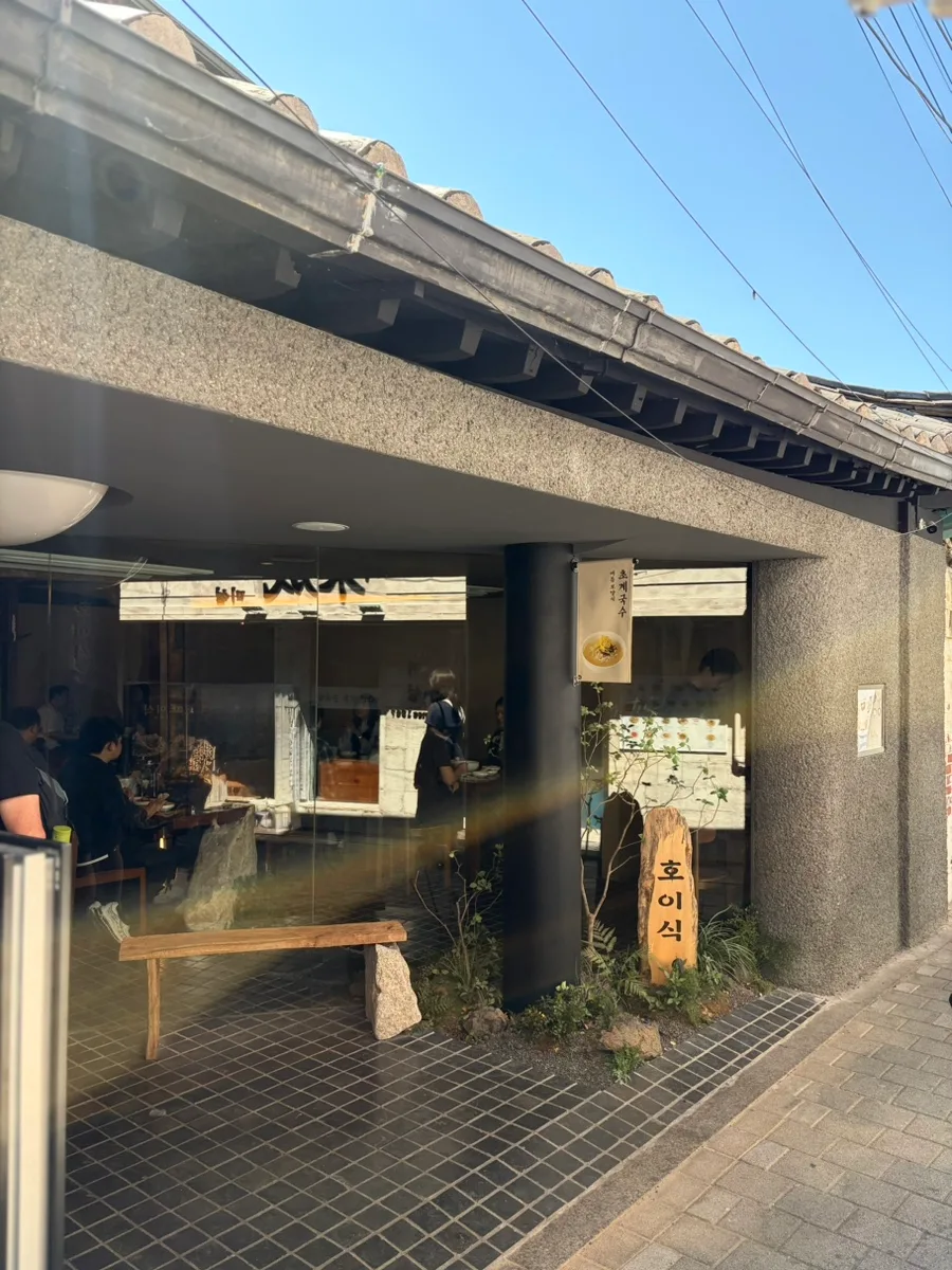 虎彝食 安国店 — 木の看板が立つホイシク