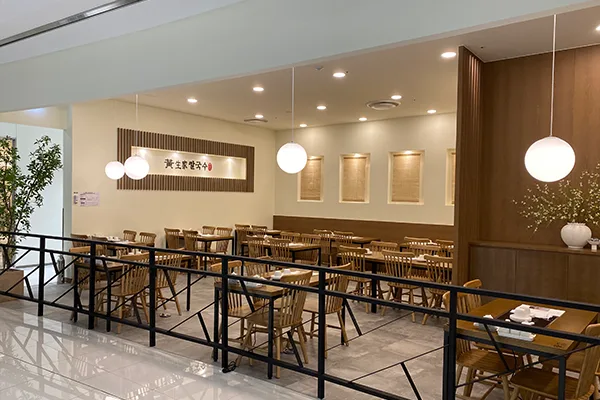 黄生家カルグクス 本店 — 丸い照明が並ぶ木調の客席