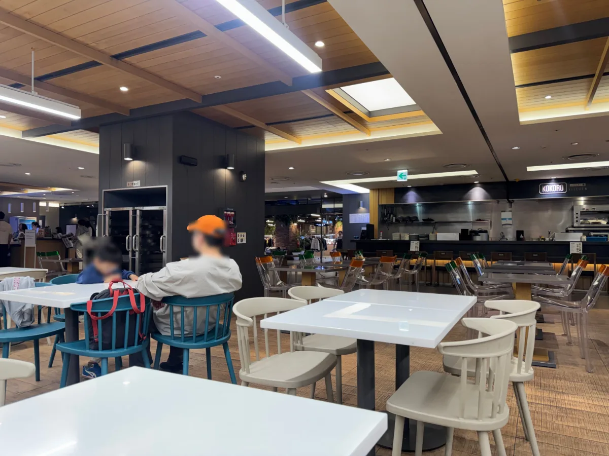 現代アウトレット 東大門店 — 木張り天井と白い卓の飲食フロア