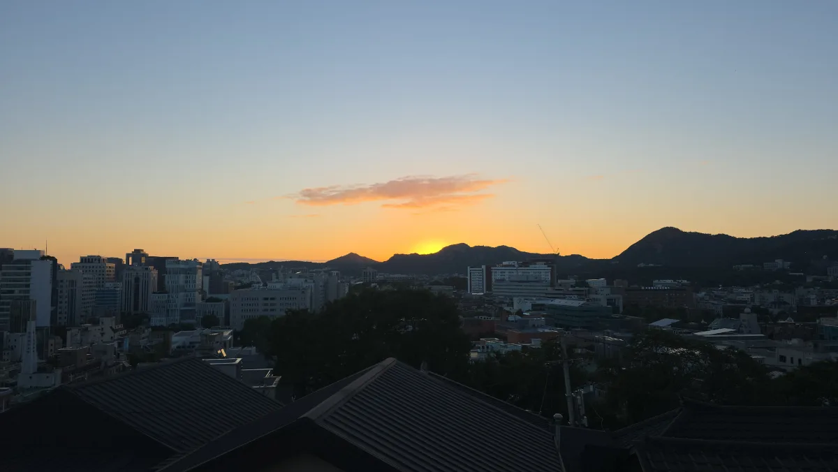 梨花村 — 夕焼けに沈む山並みと街