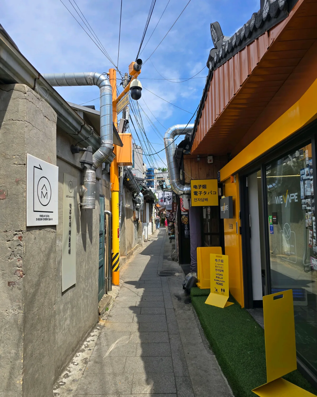 黄色い店舗脇の細い路地