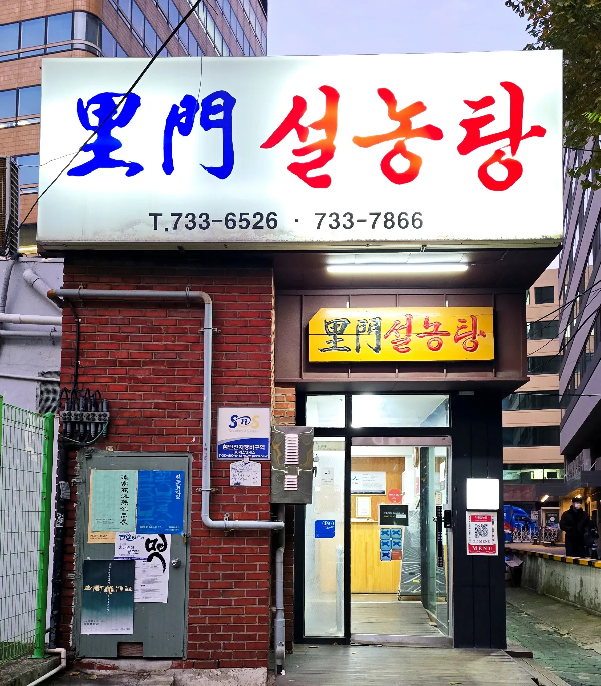 煉瓦壁と大看板の店先