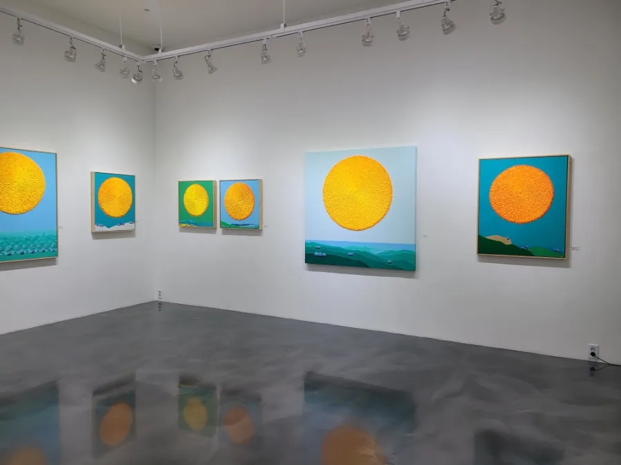 黄色い円の絵が並ぶ展示室
