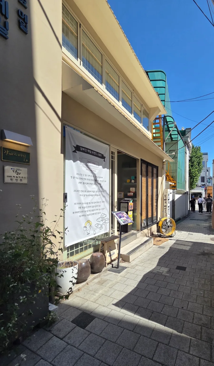 チャルパジンメミル 西村本店 — 青空に映える路地沿いの店舗